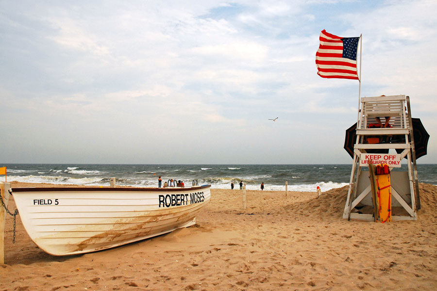 A small beach crowd brave less than ideal beach weather on a windy day at Robert Moses Beach State Park near Babylon, New York. Robert Moses State Park, is a renowned destination known for its pristine beaches, scenic landscapes, and diverse recreational opportunities. File photo: James Kirkikis, ShutterStock.com, licensed.